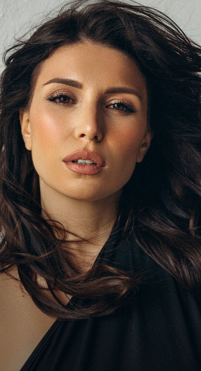 Close-up portrait of a woman with flowing hair.