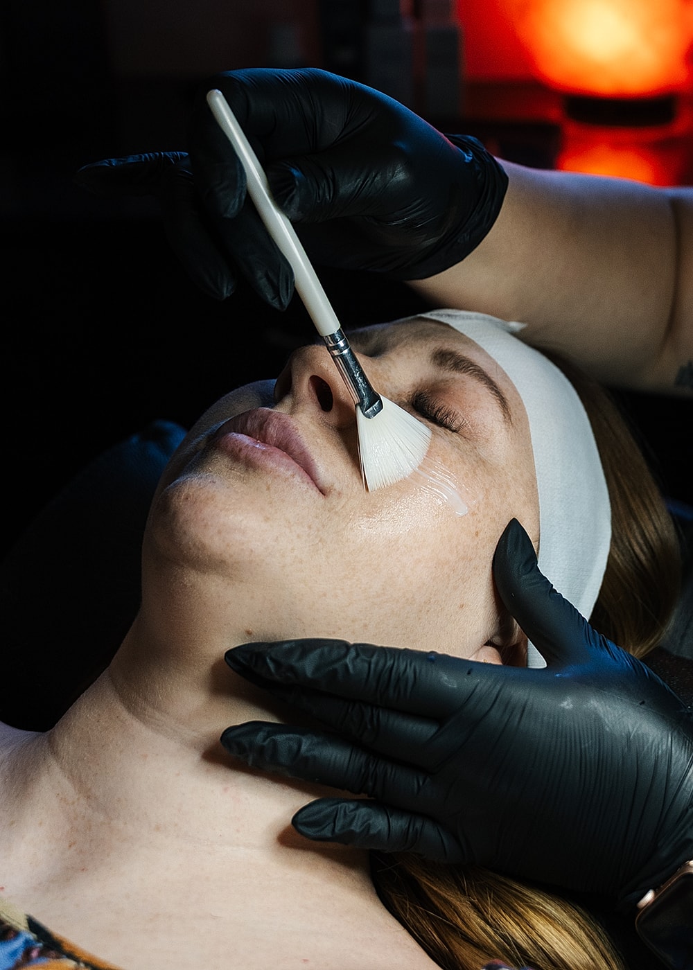 Applying facial treatment in a spa setting.