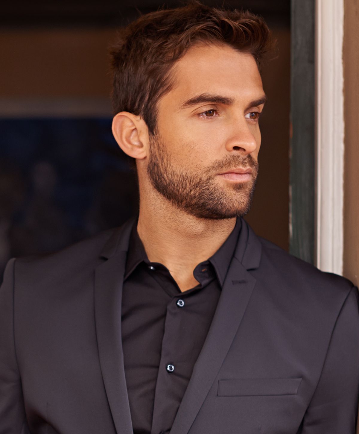 Man in formal attire looking thoughtfully off camera.