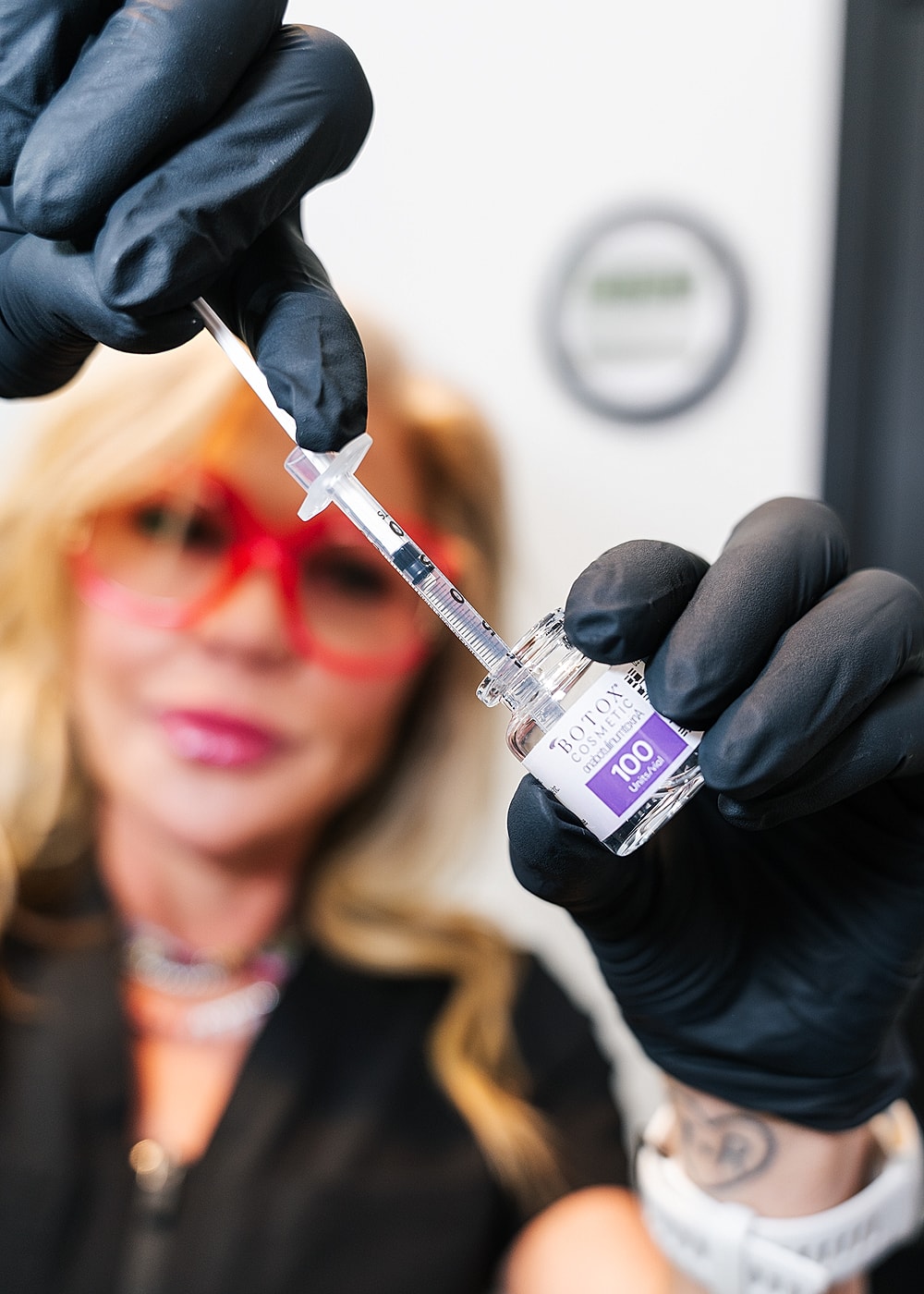 Syringe holding Botox vial before injection procedure.