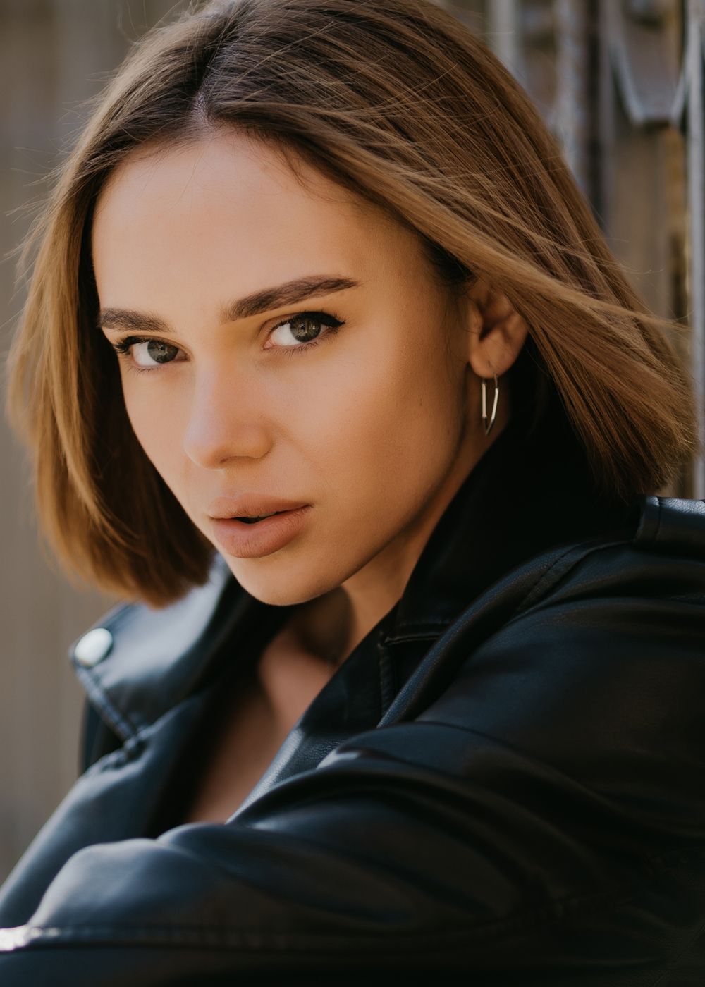 Woman with short hair and leather jacket.
