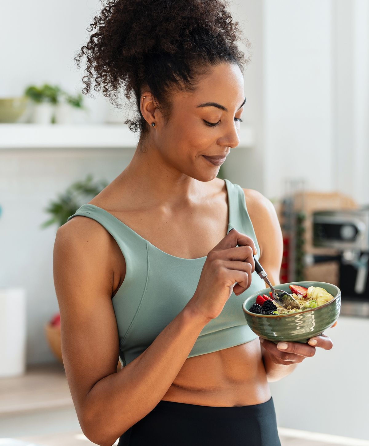 Woman enjoying a healthy meal in a bowl.