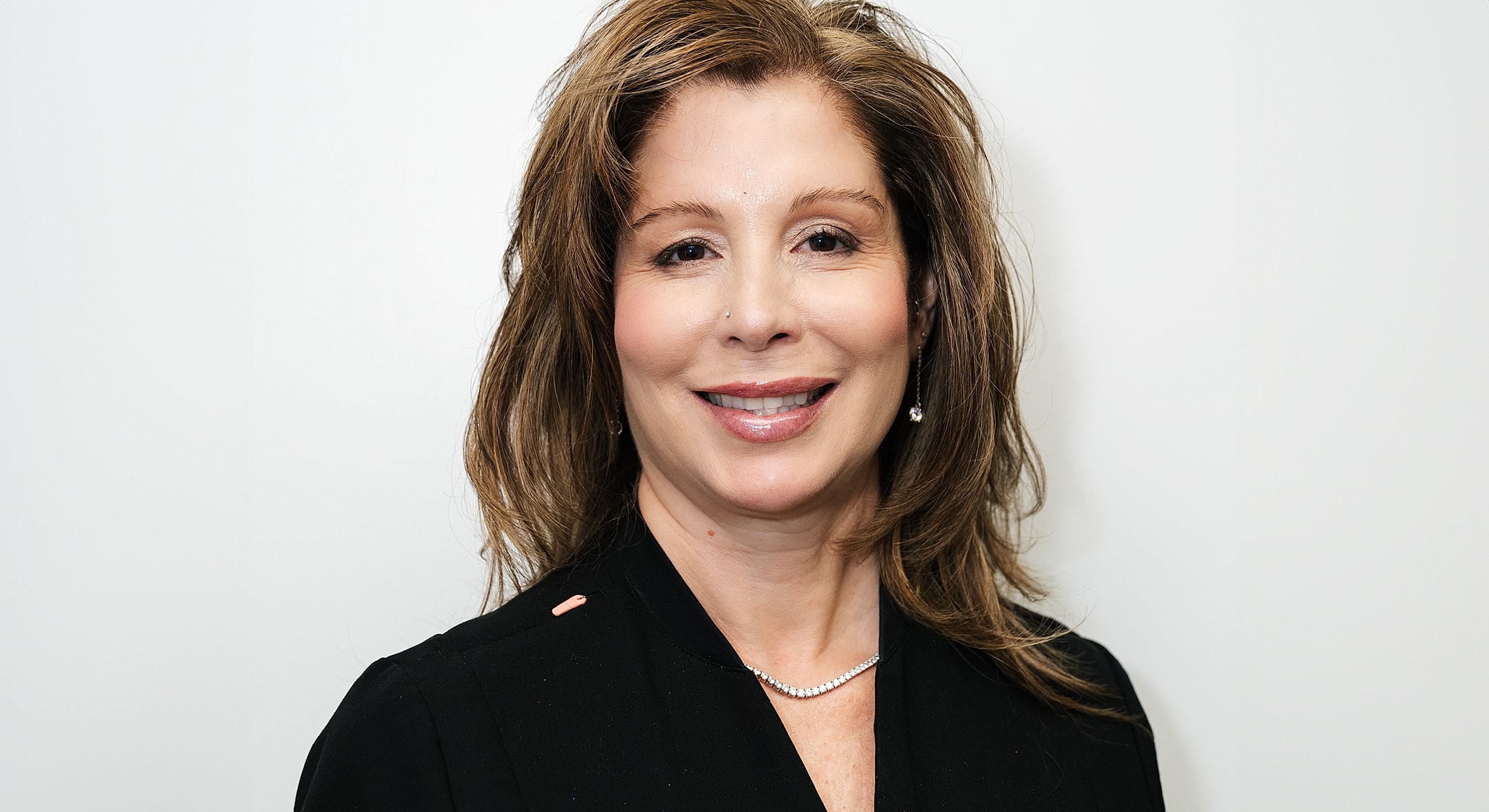 Smiling woman in professional attire against white background.