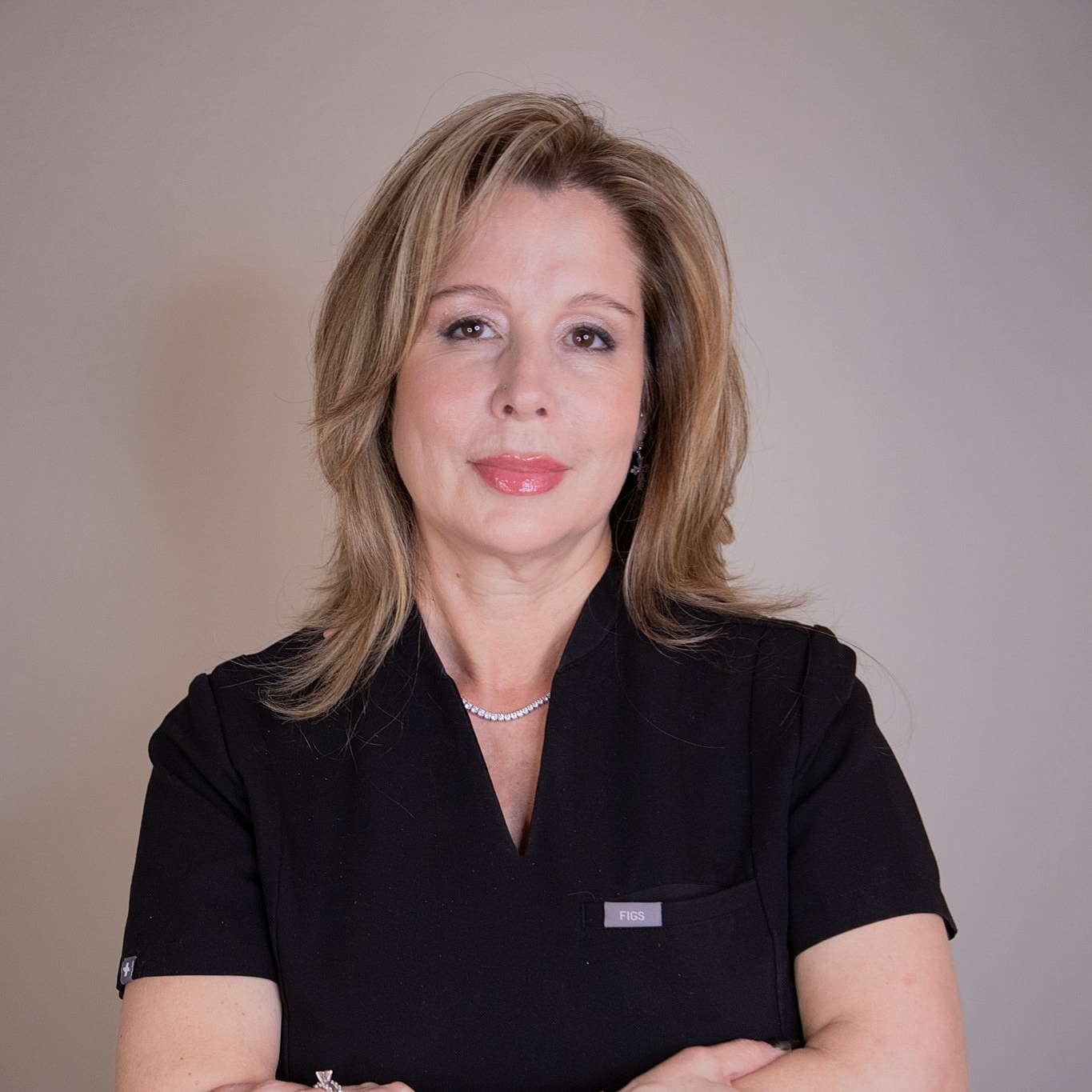 Smiling woman in professional attire against white background.
