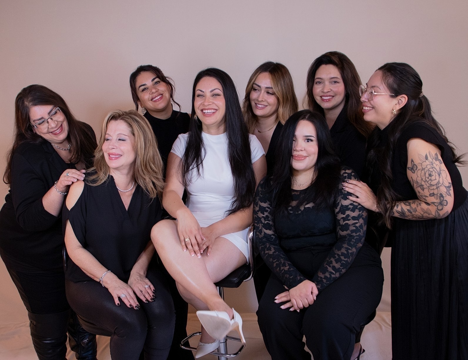 Group of professionals in black scrubs smiling together.