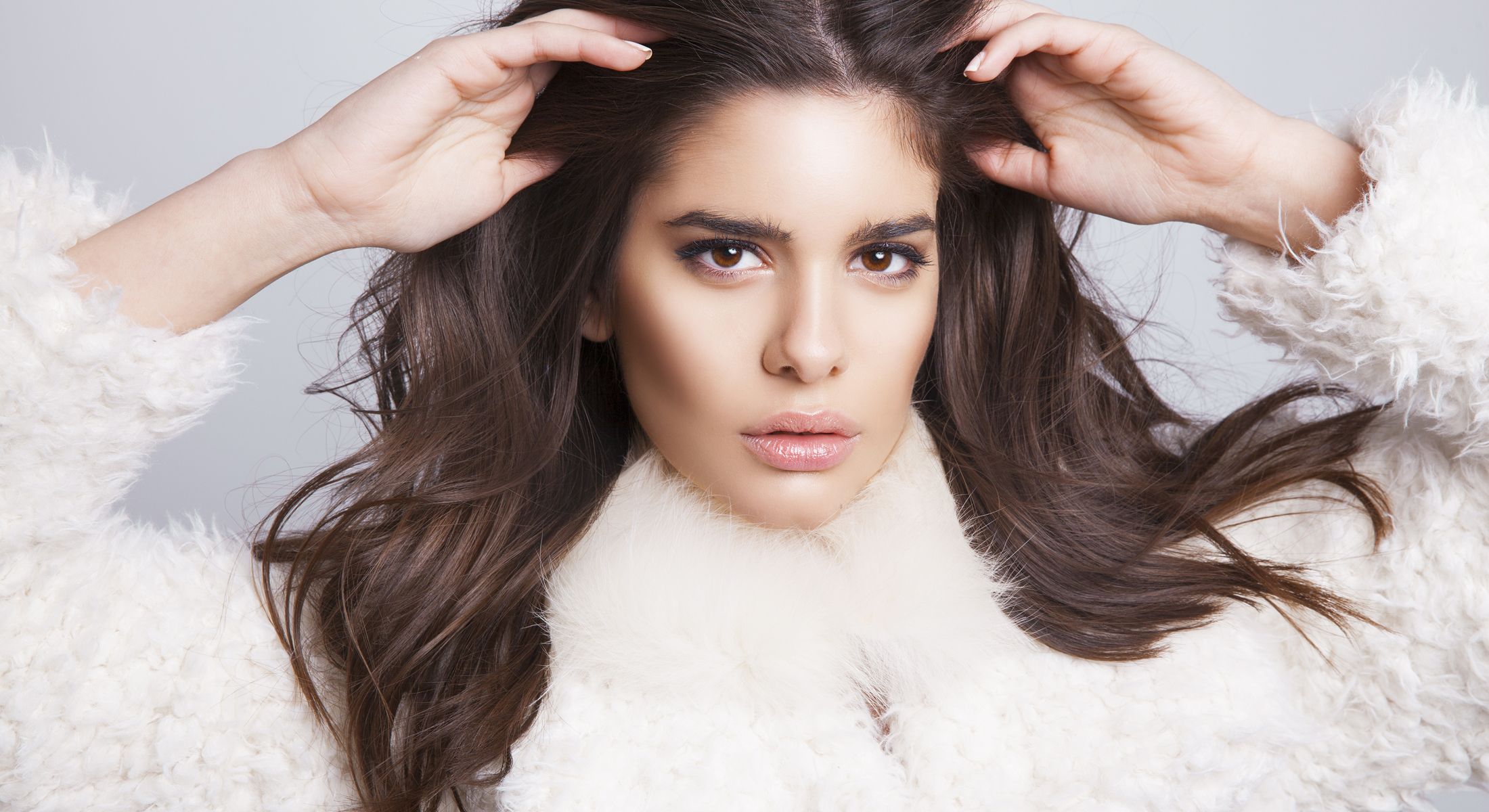 Santa Fe Injectables & Fillers model with long hair in fluffy white coat.