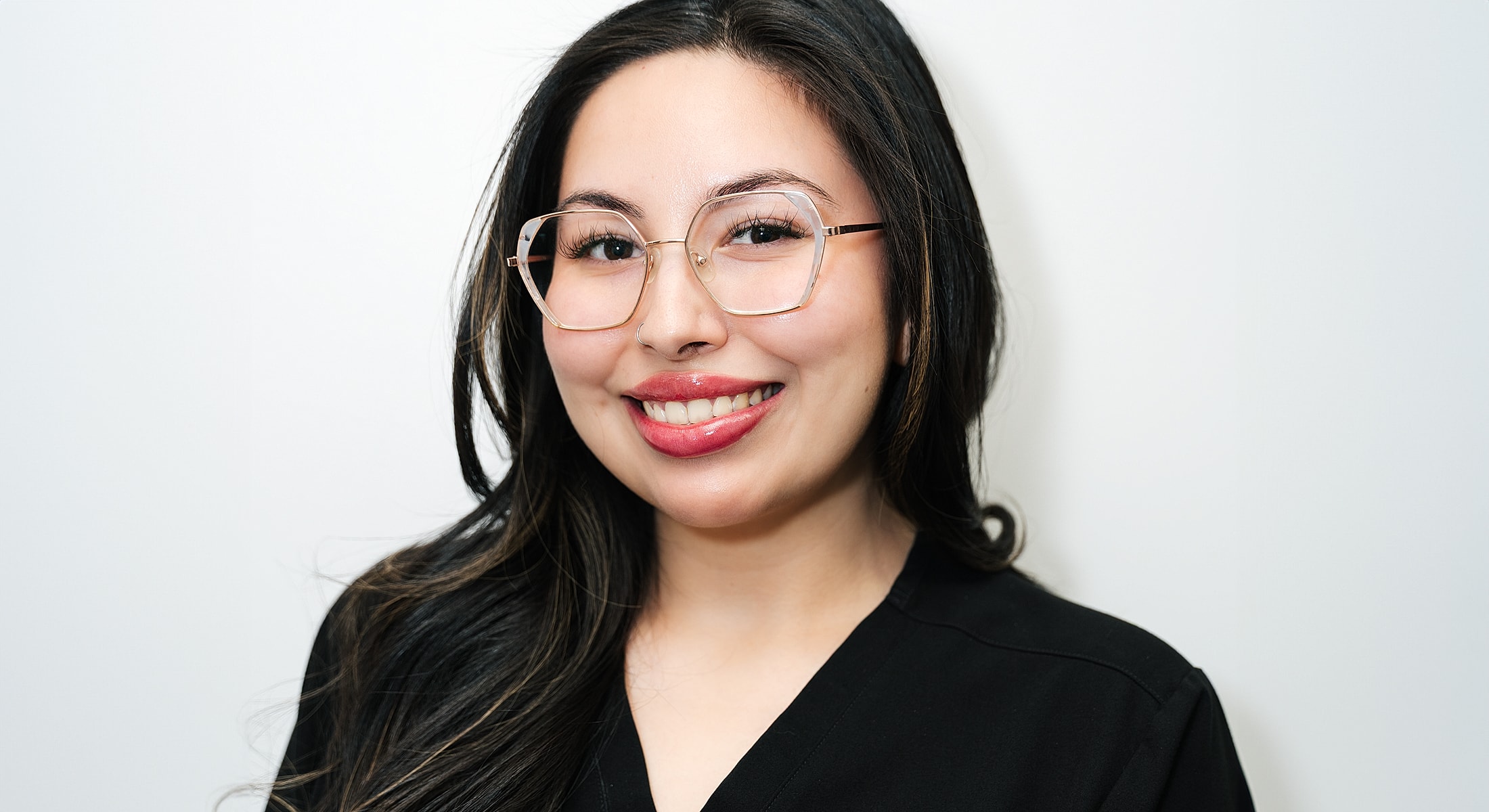 Smiling woman with glasses on a plain background