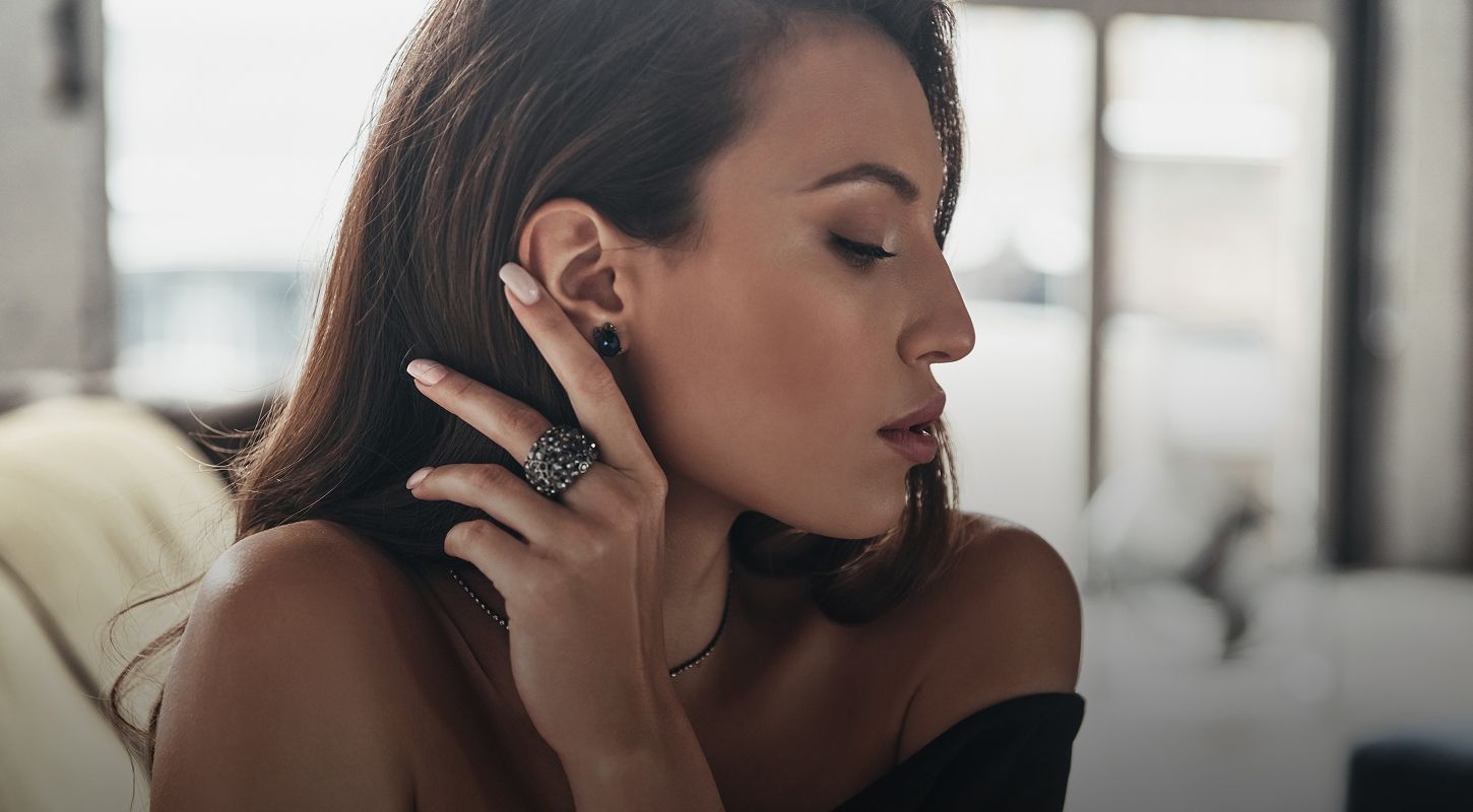 Woman showcasing elegant jewelry in profile view.