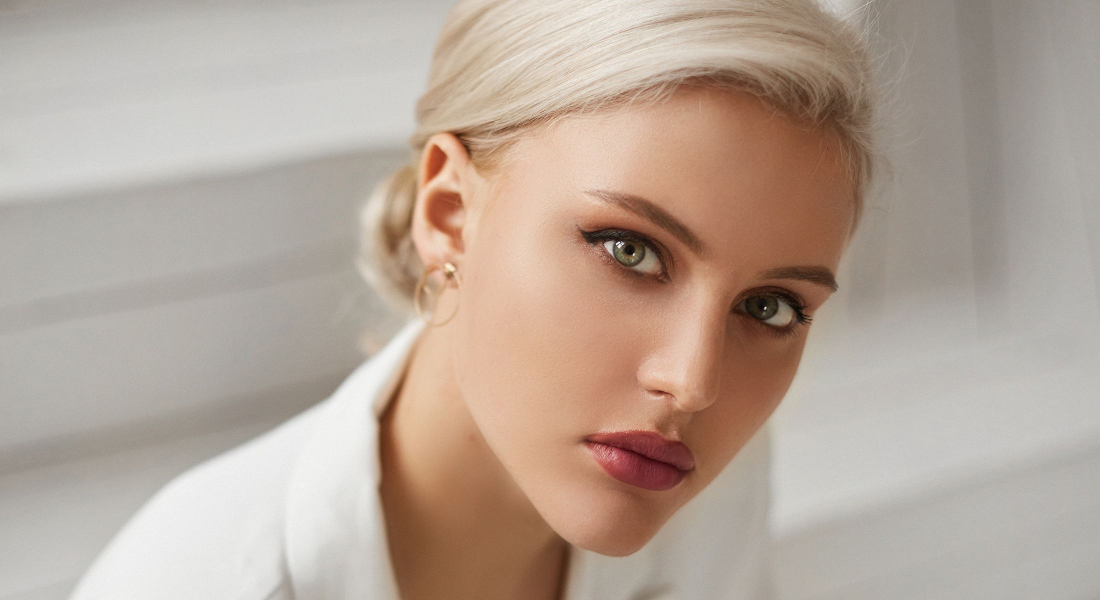 Close-up of stylish woman with piercing green eyes.