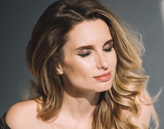 Woman with closed eyes and wavy hair.