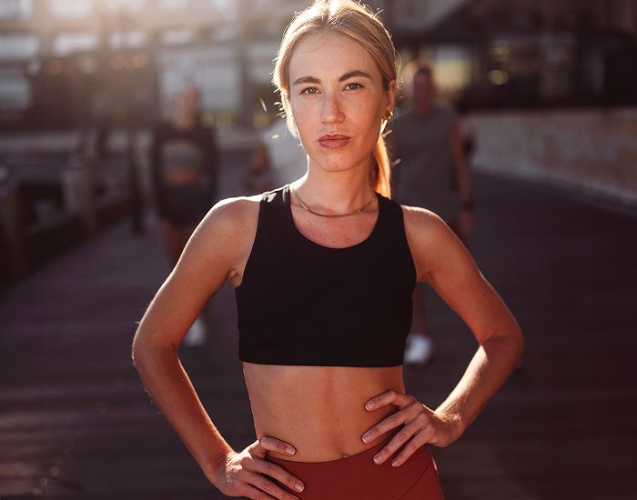 Young woman posing confidently in athletic wear.