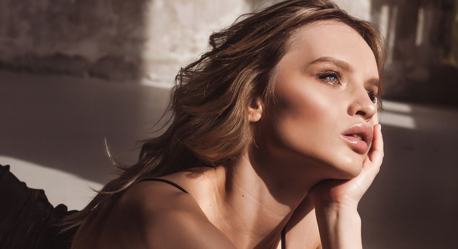 Woman gazing thoughtfully with soft lighting.