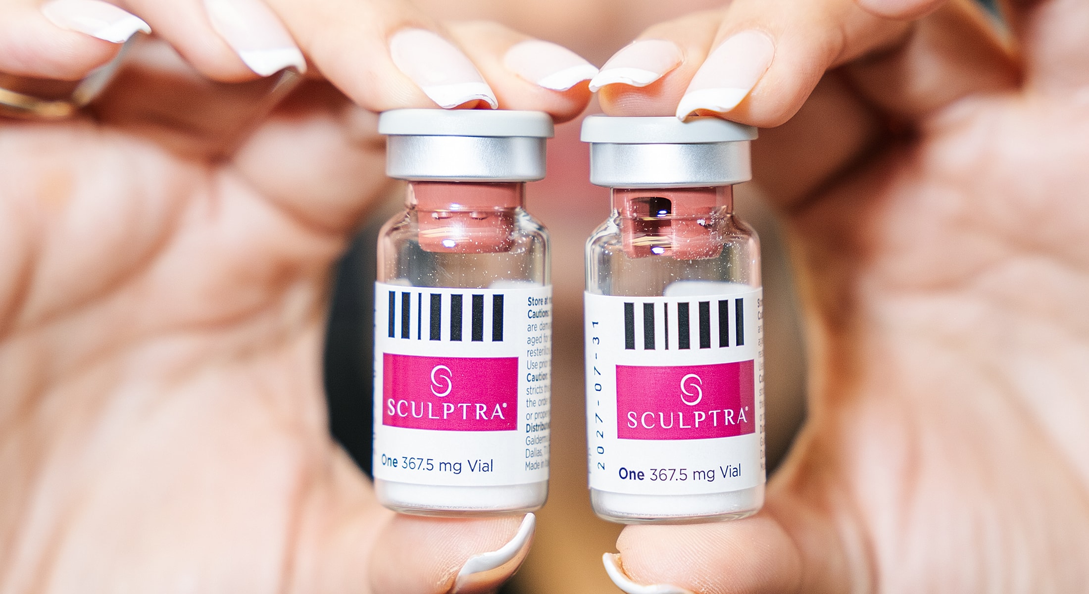 Two vials of Sculptra in hands.
