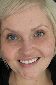 Smiling person with short blonde hair and freckles.