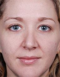 Middle-aged woman with minimal makeup, neutral expression.