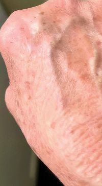 Middle-aged woman with minimal makeup, neutral expression.